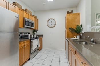 Galley kitchen with dark countertops and tiled floor