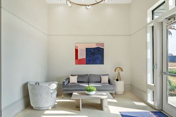 Baton Rouge apartment for rent - A modern living room with a grey couch, a grey armchair, a wooden coffee table, and a large abstract painting on the wall.