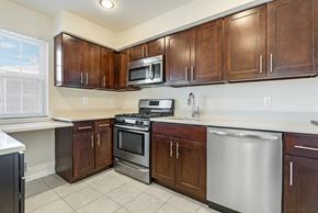 Chatham apartment for rent - A kitchen with brown cabinets and stainless steel appliances. at Chatham Hill, New Jersey, 07928