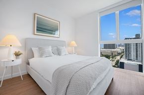 Miami apartment for rent - a bedroom with a bed and a large window