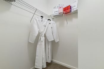 Walk-in closet with wire shelving and white robe