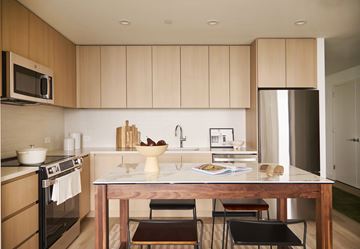 Jersey City apartment for rent - A kitchen with a table and chairs in the foreground.