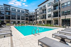 Fair Lawn apartment for rent - A swimming pool surrounded by sun loungers and apartment buildings.
