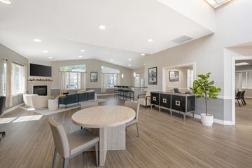 Frederick apartment for rent - A spacious living room with a large round table and chairs.