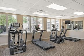 Frederick apartment for rent - A gym with treadmills, elliptical machines, and a television.