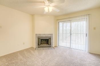 A living room with a fireplace and a ceiling fan