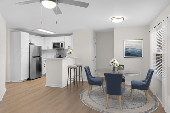 Flowood apartment for rent - A modern kitchen with a dining table set for four. at Reflection Pointe, Flowood, MS