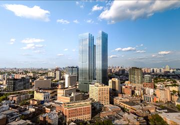 Jersey City apartment for rent - A cityscape with a large blue building in the center.