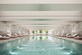 Jersey City apartment for rent - A large indoor swimming pool with lounge chairs on either side.