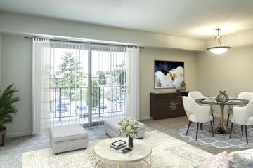 Leesburg apartment for rent - A living room with a white sofa, a round table, and a painting on the wall.