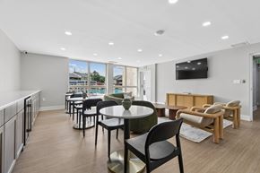 Cockeysville apartment for rent - A modern dining area with a table set for six and a television mounted on the wall.