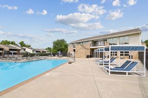 Cockeysville apartment for rent - A swimming pool with sun loungers and a building in the background.