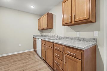 Traverse City apartment for rent - A kitchen with wooden cabinets and a marble countertop.