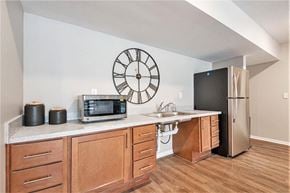 Grand Rapids apartment for rent - A kitchen with a clock on the wall and a microwave on the counter.