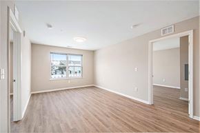 Grand Rapids apartment for rent - A spacious room with wooden flooring and a window overlooking a cityscape.