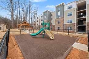 Dallas apartment for rent - A playground with a green slide in front of apartment buildings.
