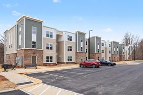 Dallas apartment for rent - A parking lot in front of a building with cars parked.