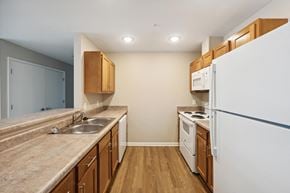 East Lansing apartment for rent - a kitchen with white appliances and wooden cabinets