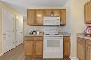 Ashland apartment for rent - a kitchen with white appliances and wooden cabinets