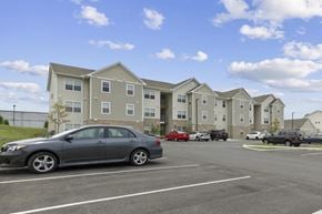 Ashland apartment for rent - a car parked in a parking lot in front of an apartment building