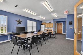 Walbridge apartment for rent - A conference room with a long table and chairs, a television, and a star decoration on the wall.