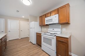 Whitehall apartment for rent - A kitchen with a white stove and a white microwave above it.