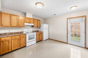 Indiana apartment for rent - a kitchen with white appliances and wooden cabinets