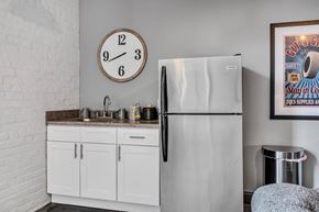 Cleveland apartment for rent - a kitchen with a sink refrigerator and a clock on the wall