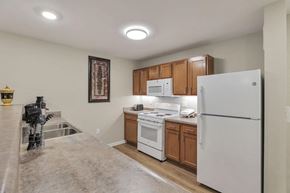 Columbus apartment for rent - a kitchen with white appliances and wooden cabinets