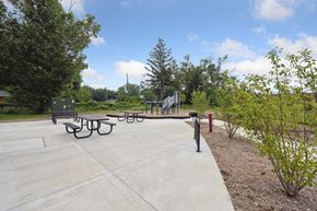 East Lansing apartment for rent - a paved area with picnic tables and a playground in the background