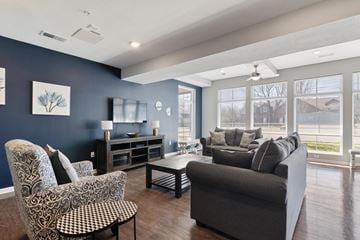 Hopkinsville apartment for rent - A living room with a grey sofa, a patterned chair and a coffee table.