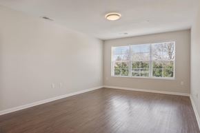 Hopkinsville apartment for rent - A spacious room with a large window and wooden flooring.