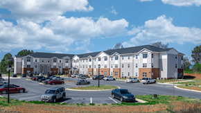 Statesville apartment for rent - a parking lot with cars in front of an apartment building