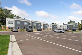 East Lansing apartment for rent - a parking lot with cars in front of an apartment complex