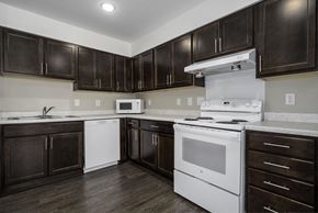 Statesville apartment for rent - a kitchen with white appliances and dark wood cabinets