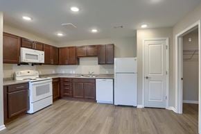 Shippensburg apartment for rent - A kitchen with brown cabinets and white appliances.