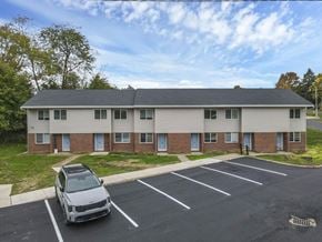 Barnesville apartment for rent - A white car is parked in a parking lot in front of a building.