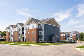 Columbus apartment for rent - A large multi-story residential building with a parking lot in front.