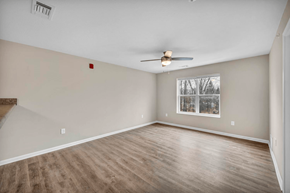 Parma apartment for rent - an empty living room with a ceiling fan and a window