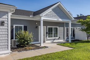 Muncy apartment for rent - the front of a gray house with a sidewalk and grass