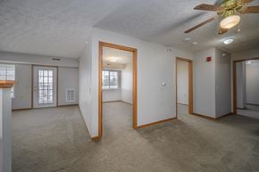 Fostoria apartment for rent - A spacious room with a ceiling fan and carpeted floor.