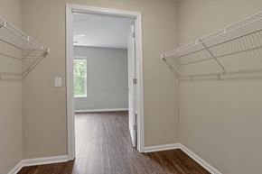 Columbus apartment for rent - a bedroom with a closet and a door open to a room with wood flooring