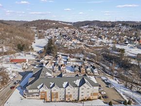 Waynesburg apartment for rent - A large building with a grey roof is surrounded by a parking lot.