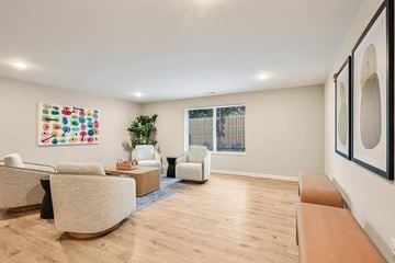 Hendersonville apartment for rent - A living room with a white couch, a chair, a coffee table, and a painting on the wall.
