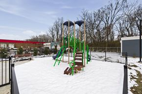 Columbus apartment for rent - A playground with a green slide and a red building in the background.
