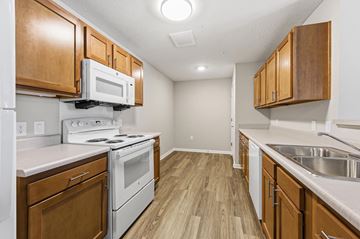 Columbus apartment for rent - A kitchen with wooden cabinets and white appliances.