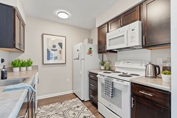 Cedar Rapids apartment for rent - A kitchen with a white stove top oven and a white refrigerator.
