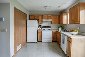 Van Wert apartment for rent - A kitchen with wooden cabinets and a white refrigerator.