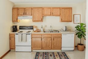 London apartment for rent - A kitchen with wooden cabinets and white appliances.