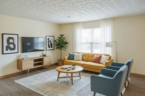 London apartment for rent - A living room with a yellow couch, a wooden coffee table, and a television on a wooden cabinet.